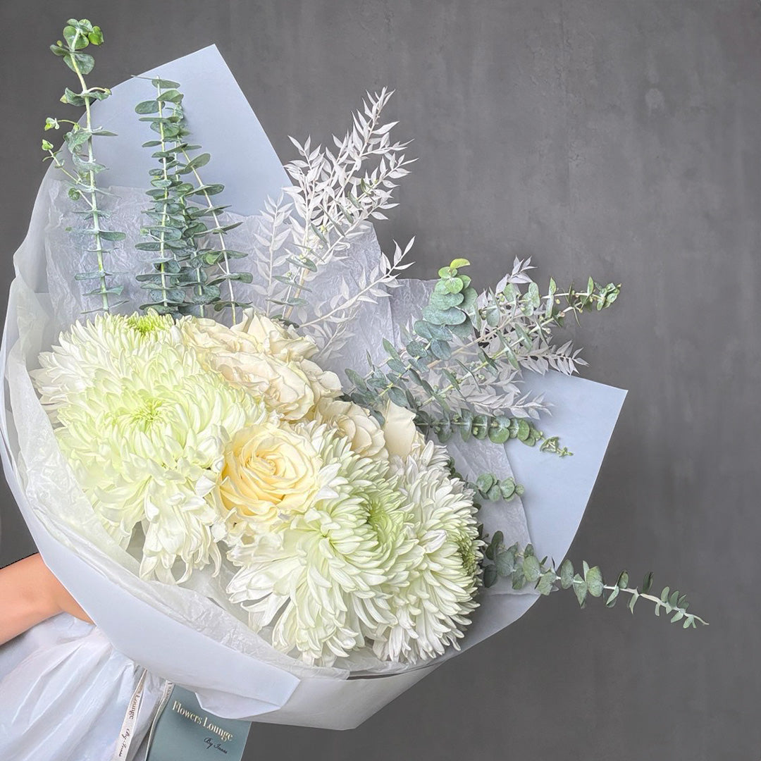 White winter bouquet with roses, chrysanthemums, and eucalyptus wrapped in pastel paper – elegant seasonal floral gift for Los Angeles delivery