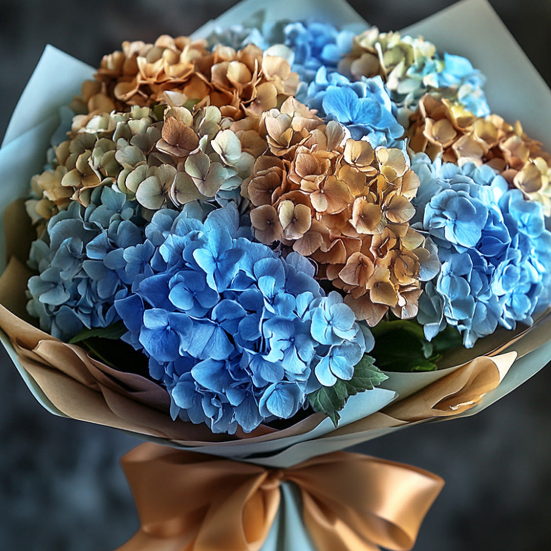 Chic bouquet of blue and golden dried hydrangeas wrapped in elegant paper with a satin bow — a sophisticated arrangement by Flowers Lounge by Iness, perfect for stylish celebrations or refined interiors