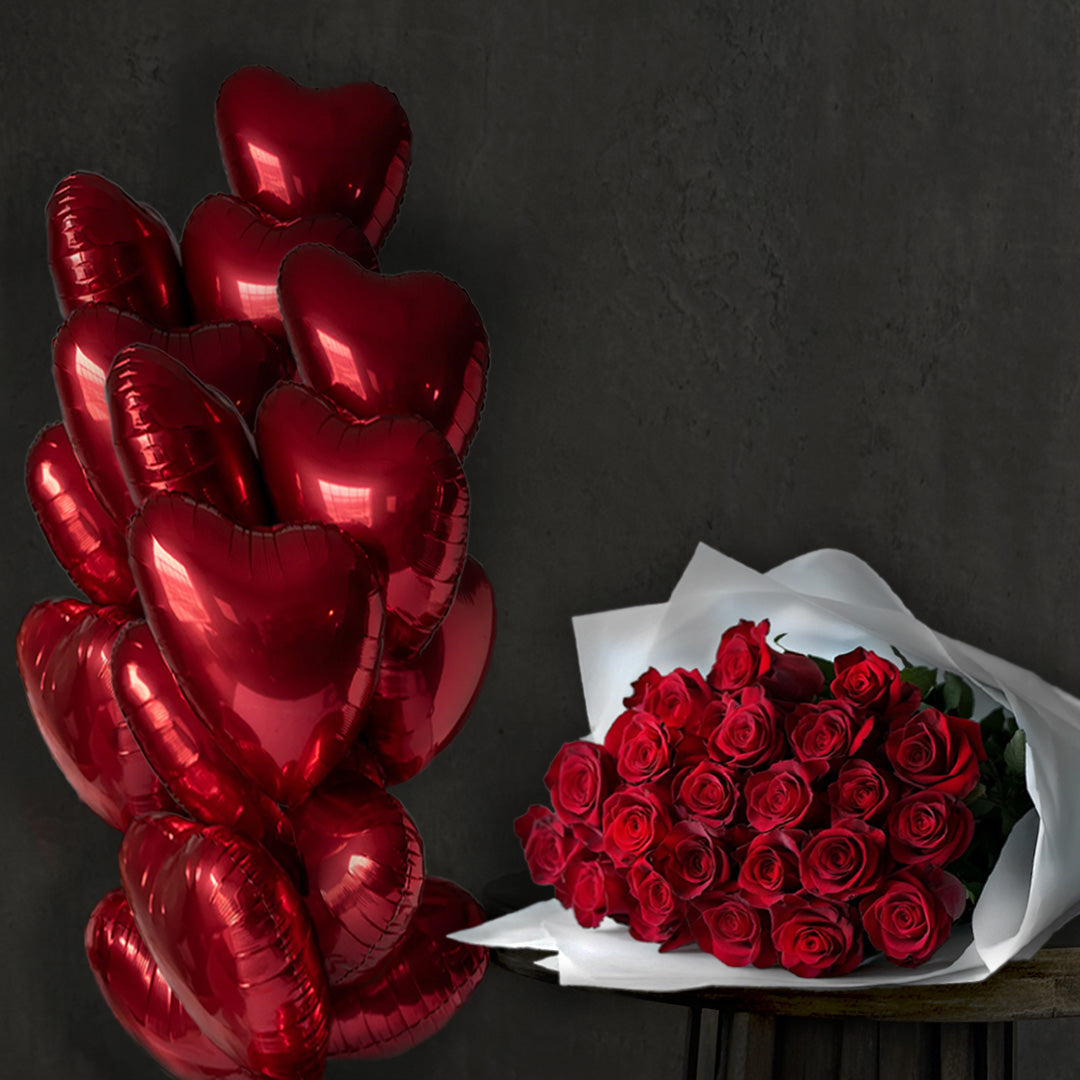 Romantic gift set with heart-shaped red foil balloons and luxury bouquet of red roses wrapped in white paper – perfect for Valentine's Day, Mother's Day, anniversary, or romantic celebration by Flowers Lounge by Iness