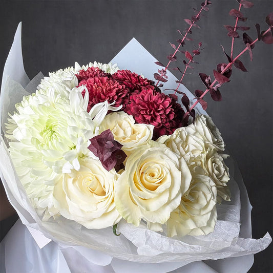 White rose and burgundy chrysanthemum bouquet wrapped in white paper with deep-toned foliage – Blushed Ivory
