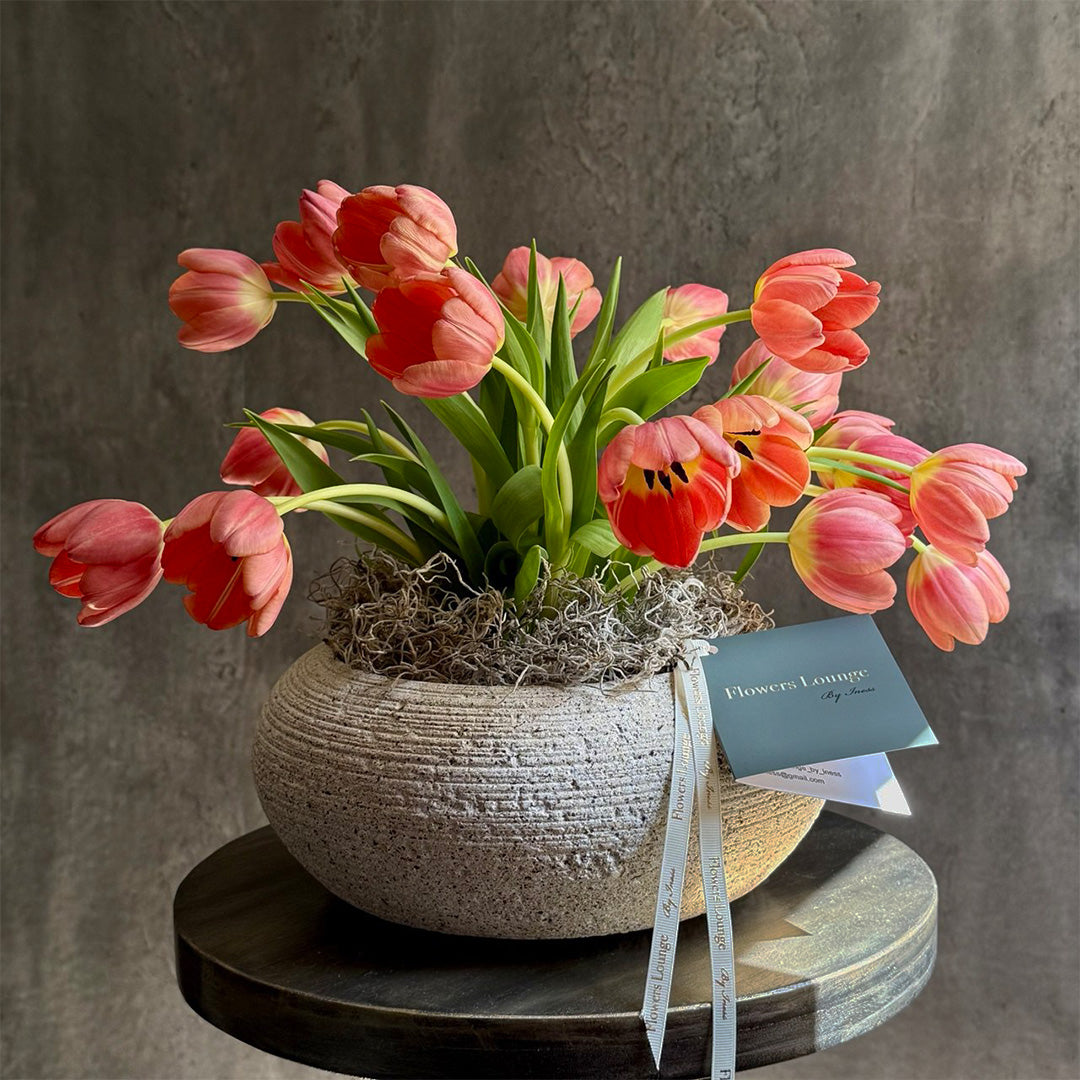 Peach tulip floral arrangement in a stone planter from Flowers Lounge by Iness. Perfect for elegant home decor, this seasonal bouquet adds charm and sophistication to any room.