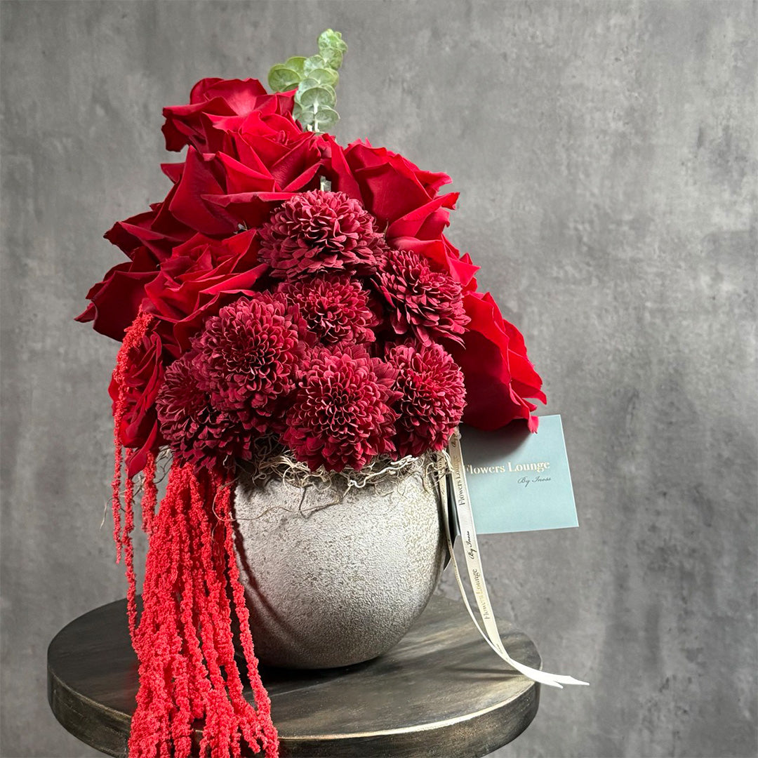 Elegant deep red floral arrangement featuring roses and chrysanthemums in a modern cement vase – Crimson Noir by Flowers Lounge, available for delivery in Los Angeles.